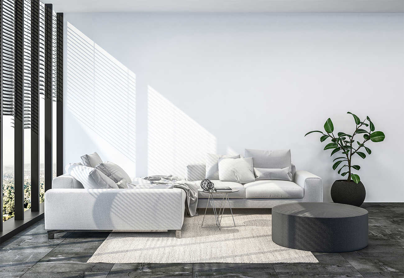 Minimalist living room with lowline grey sofa next to full windows.