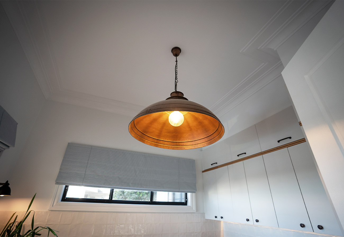 Large copper ceiling light in a modern laundry.