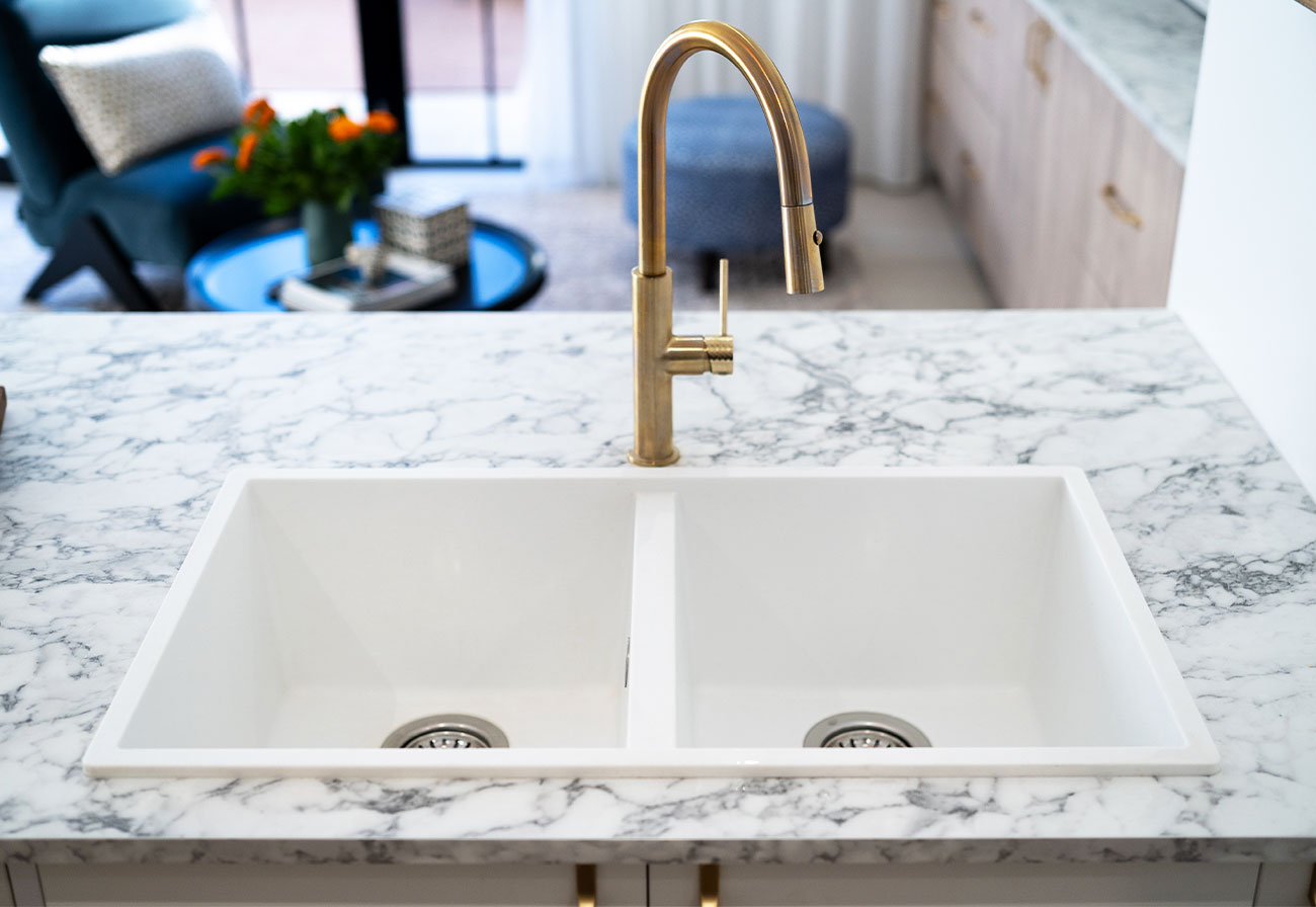 White double granitek sink with brushed brass tap.