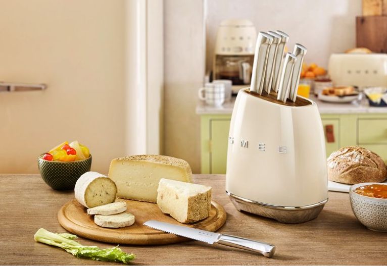 SMEG knives on a kitchen bench with a cheese board.