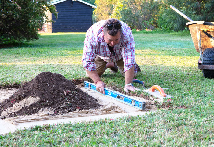 Jason Hodges levelling a backyard fire pit base