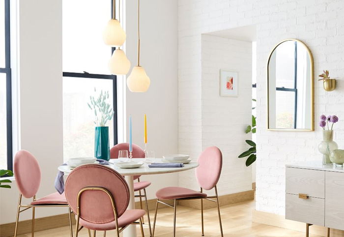 Gold mirror mounted on a white brick wall in a casual European-style living room.