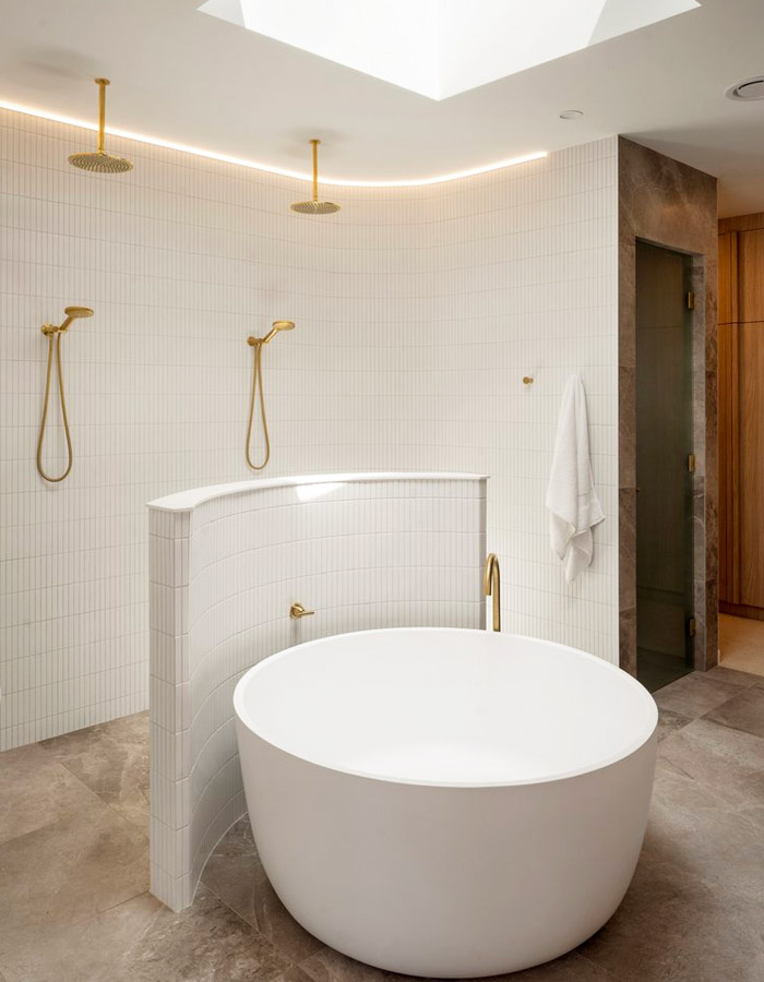 Modern bathroom with curved wall and round tub.