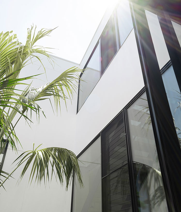 Exterior walls of a modern home finished with white concrete cladding.