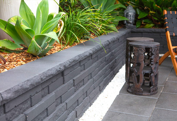 A concrete brick retaining wall in a balinese-themed courtyard.