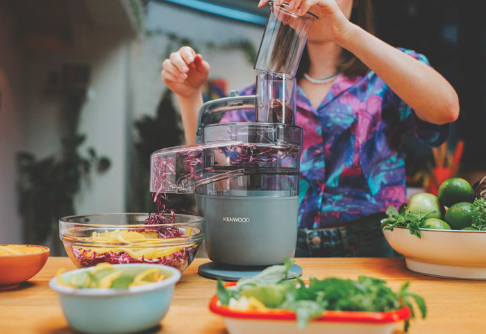 Woman using the Kenwood MultiPro Go Food Processor on a bench.