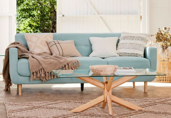 Bella coffee table next to a blue sofa.