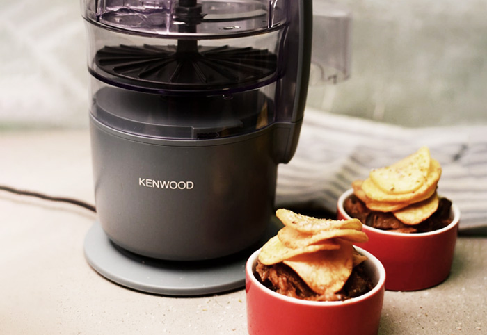 Red ramekins filled with food next to a mini food processor.