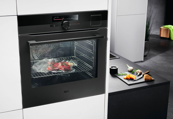 AEG black oven mounted in white kitchen cabinetry.