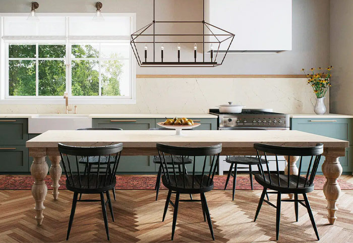 Farmhouse-style kitchen with green shaker cabinets and large dining table.