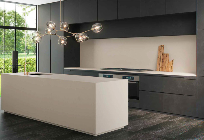 Contemporary kitchen with dark cabinets and a light stone bench and splashback.