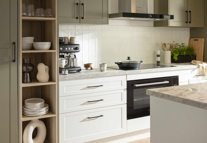 Modern green and white kitchen with black pull handles.