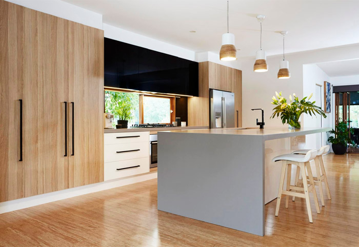 Grey stone waterfall kitchen bench in a timber kitchen. 