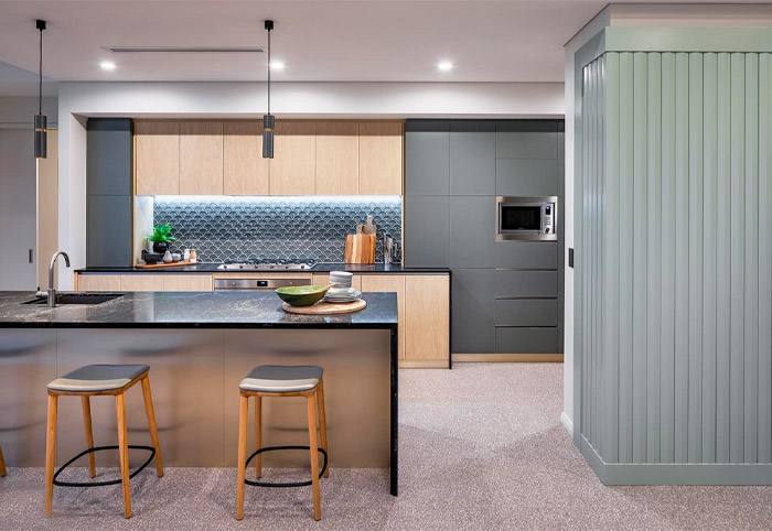 Modern black stone kitchen with contrasting stools and timber accents.