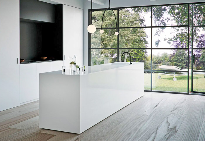 Slimline stone kitchen bench with contrasting black tap and lighting. 