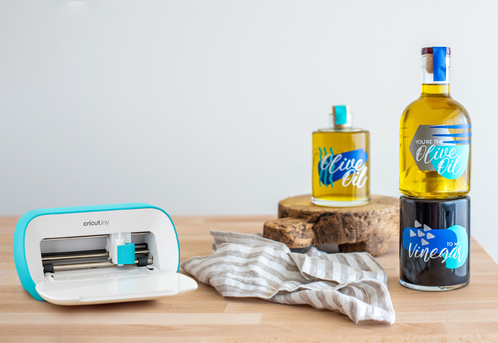 Cricut Joy machine on a table with labelled bottles.