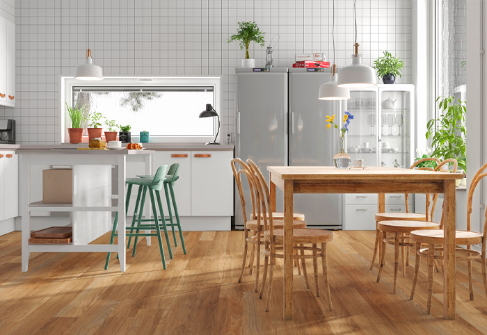 Mid-brown hybrid floorboards in a kitchen with a wooden dining table.