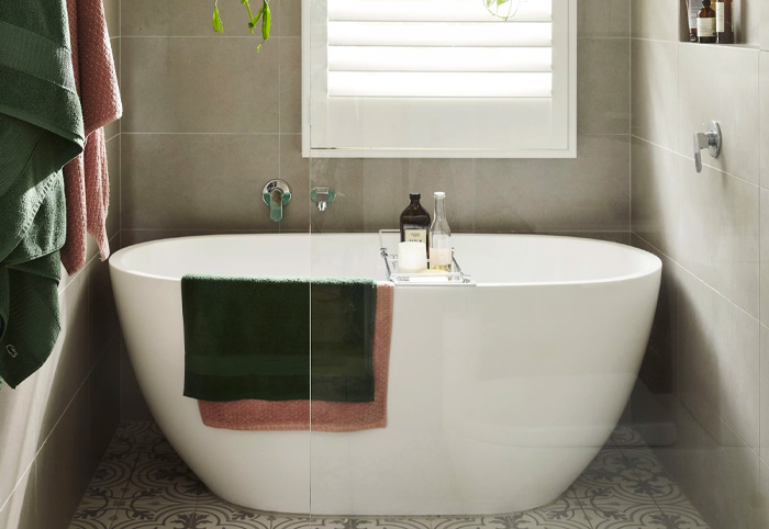 Early Sttler Milini Bathtub behind a glass shower screen.