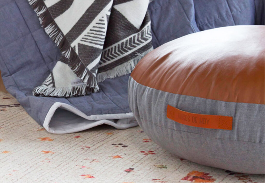 Close up of partial leather floor pad next to a bed.