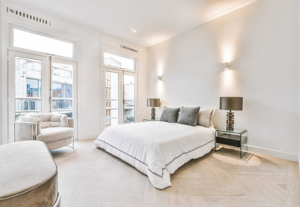 Modern bedroom with large bed, white ceilings and cornice.