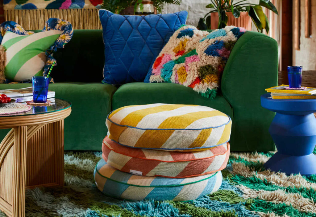 Colourful living room featuring a green sofa and coloured floor cushions.