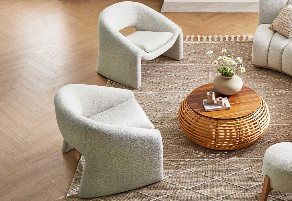 Two boucle armchairs places opposite a curved couch.