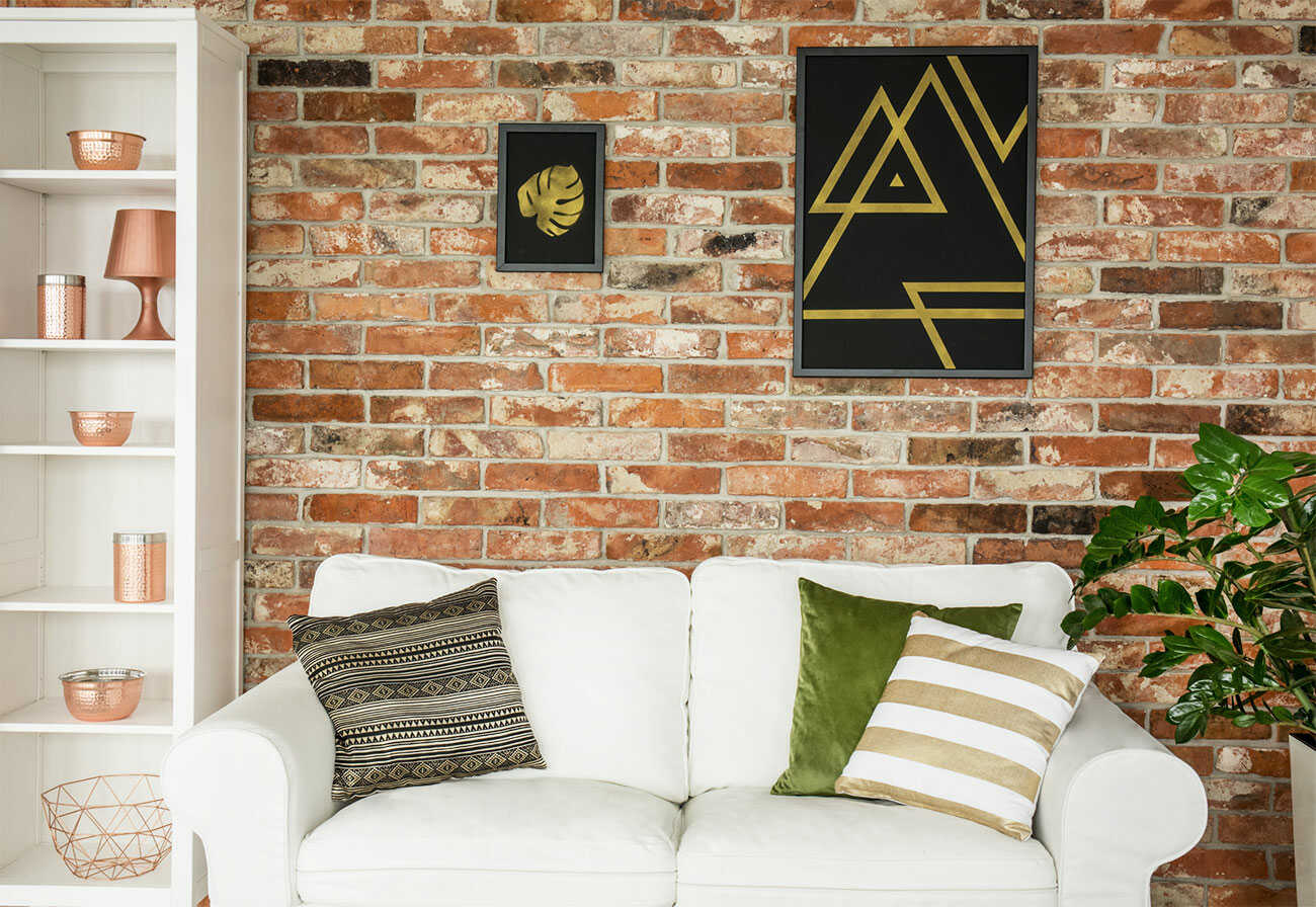 White sofa against a red brick wall.