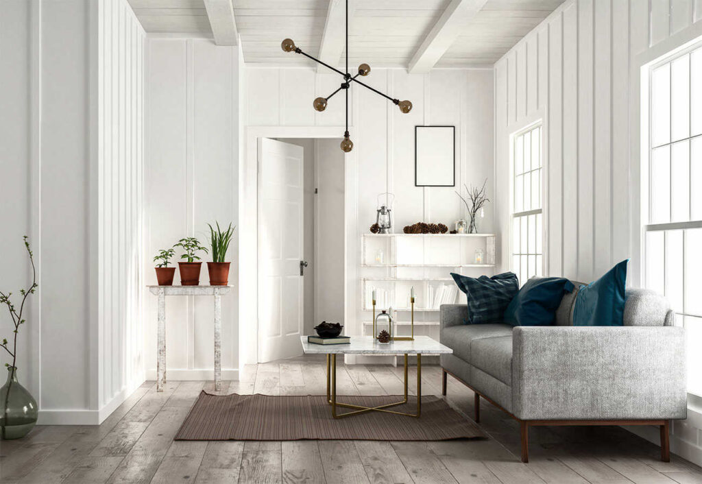 A white sitting room with a grey couch and minimalist decor.