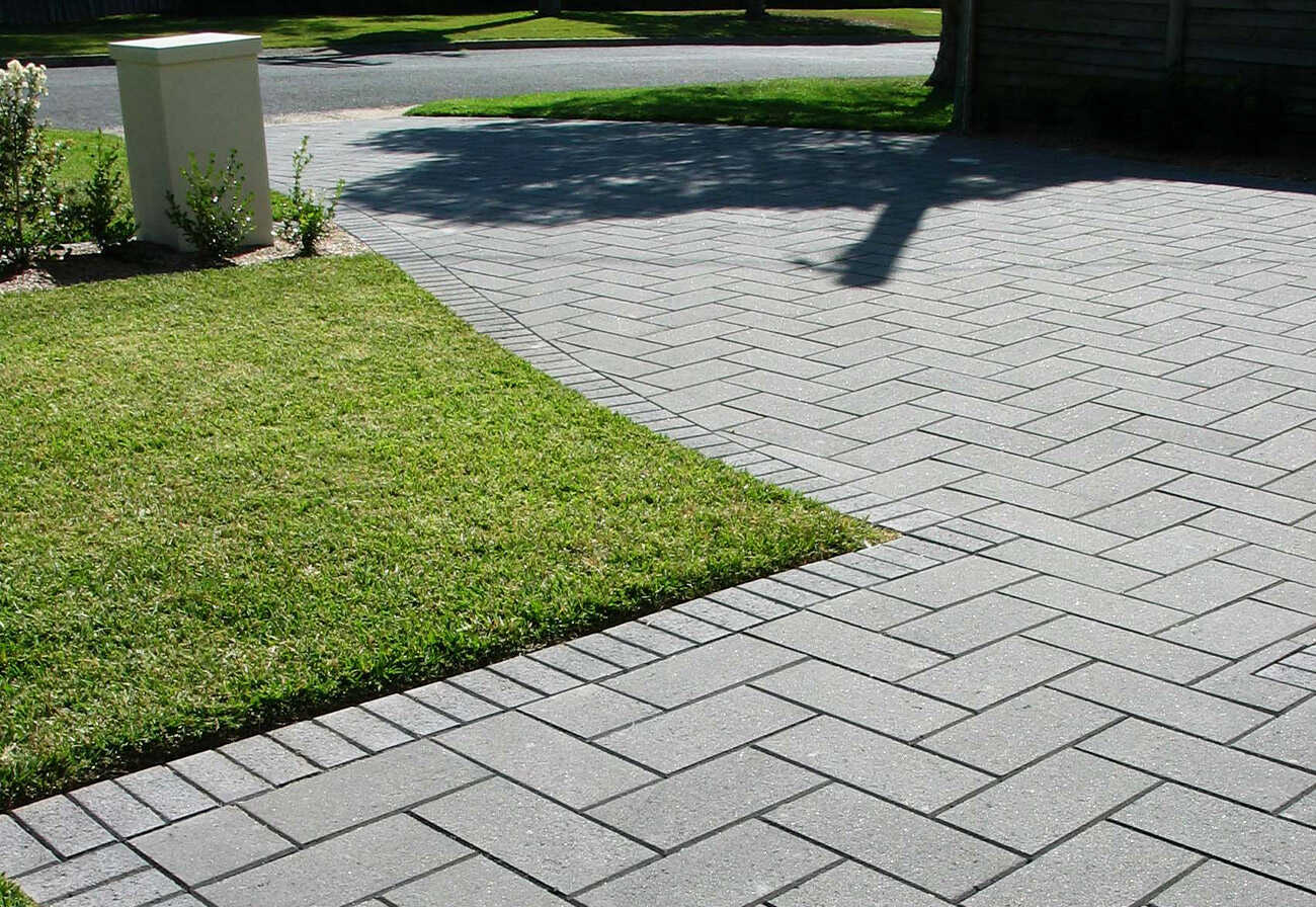 A concrete-paved driveway and lush green lawn.