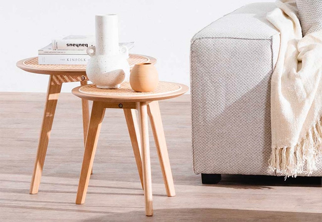 Set of wooden side tables next to a grey fabric sofa.