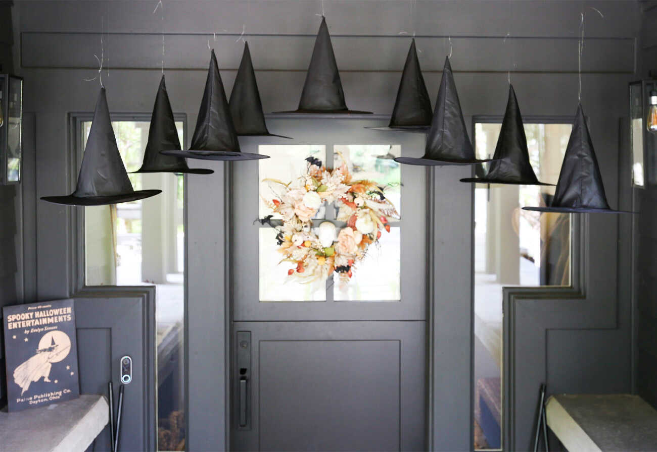 Floating witches hats at a home's entrance for Halloween.