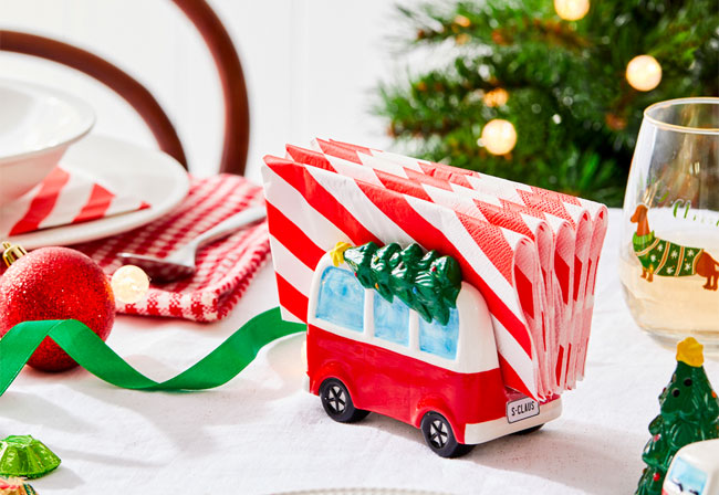 A Christmas-themed napkin holder on a dining table.