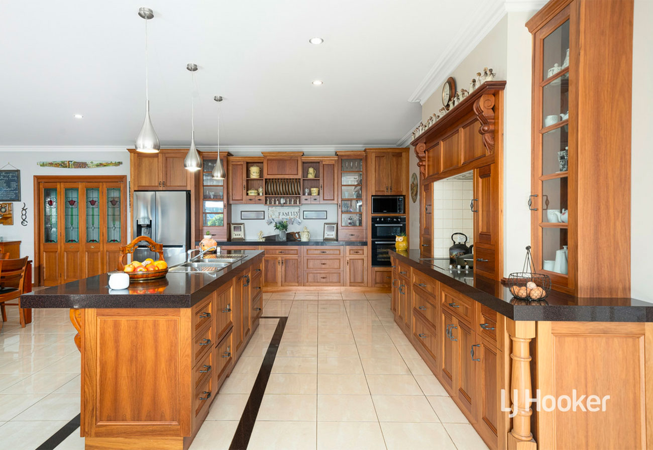 Country kitchen with solid wood cabinetry and black granite bench.