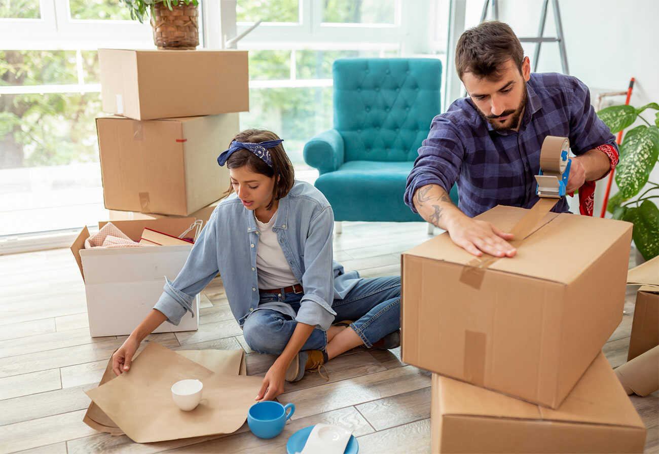 Couple packing boxes preparing to move house.