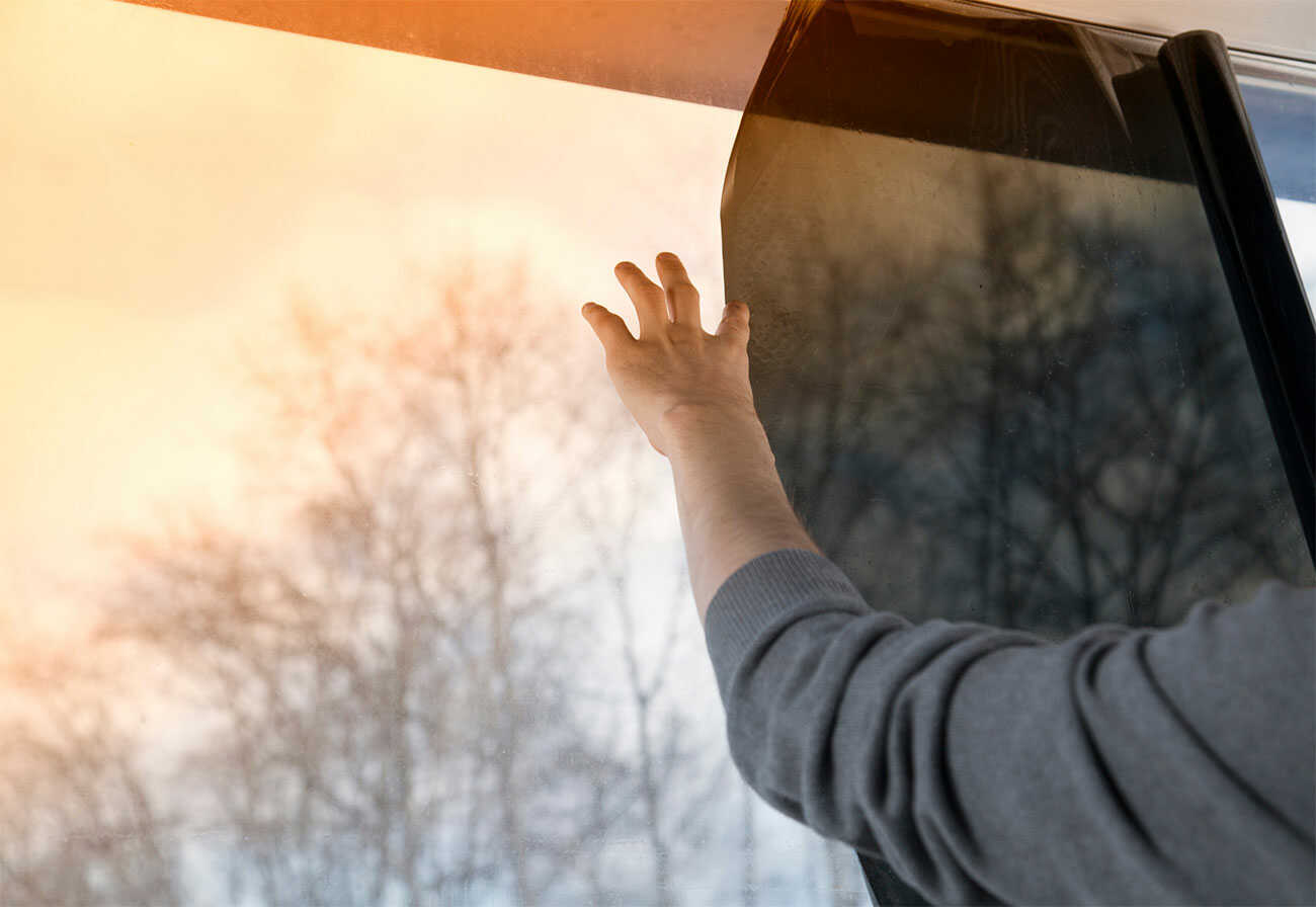 Man applies blockout film to a window.