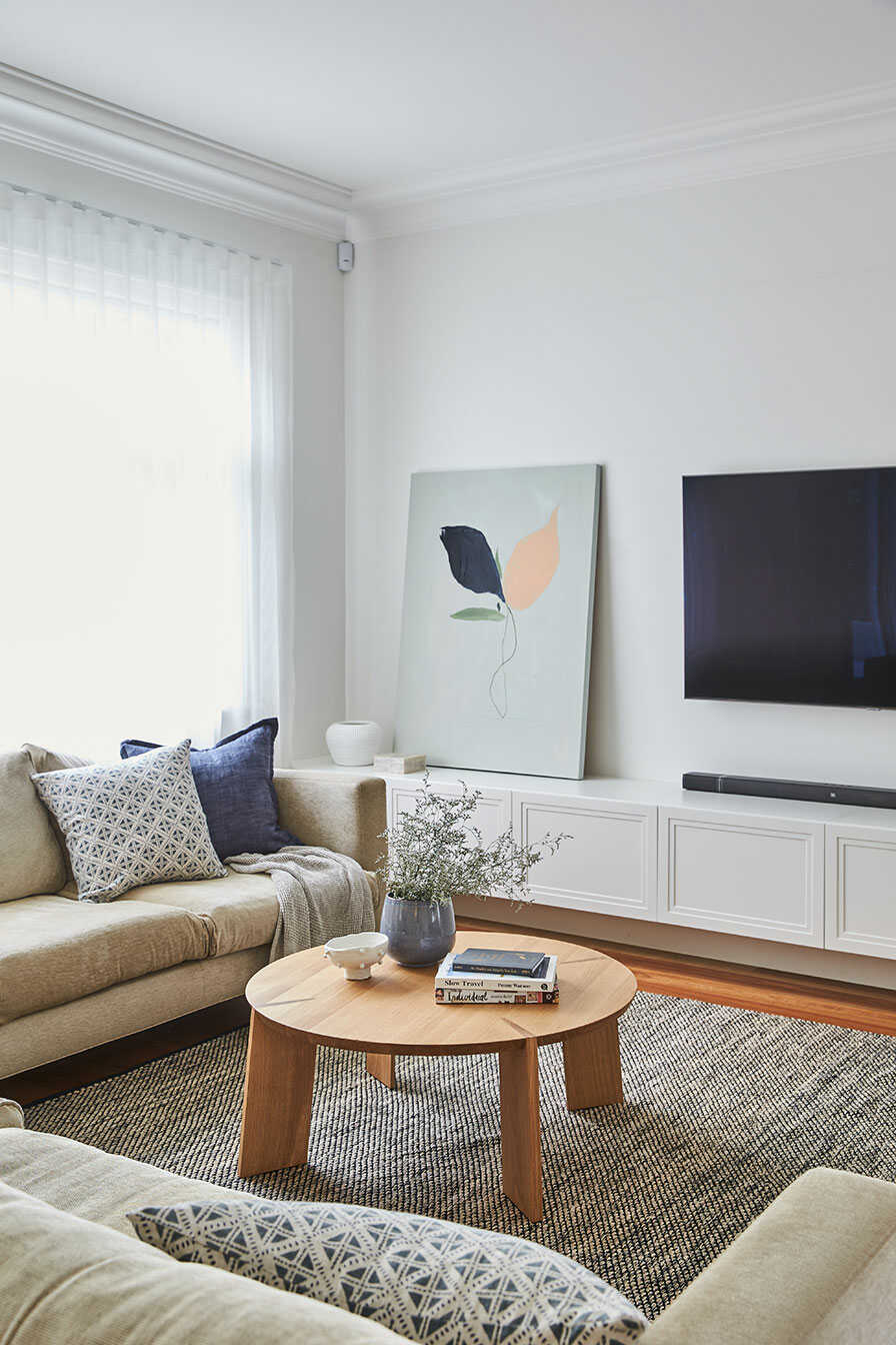 Modern living room with sofa, rug and sheer curtains.