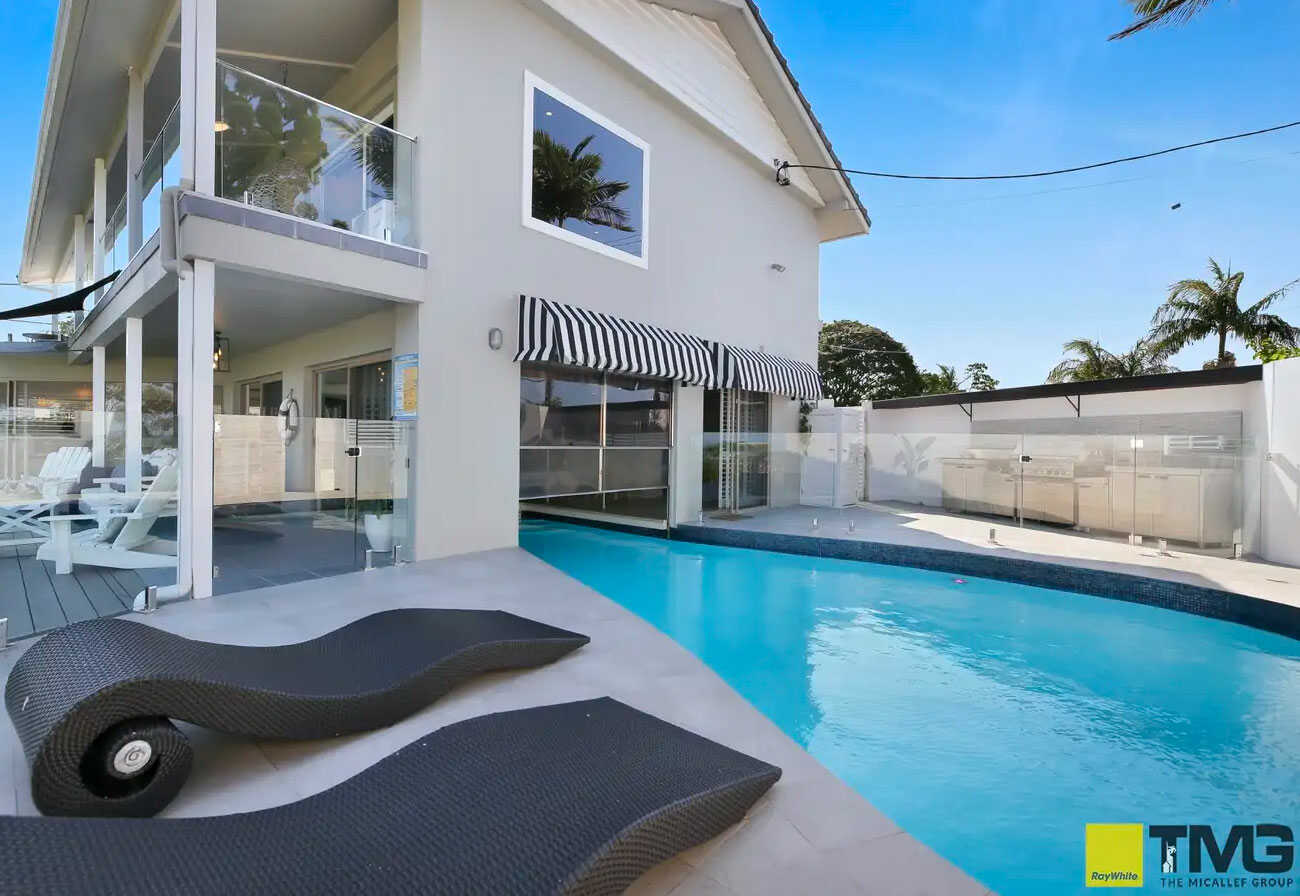 Pool terrance of a modern family home with sun lounges. 