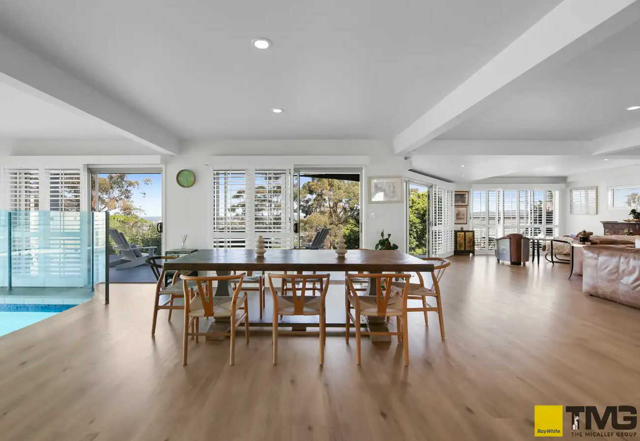 Open plan living and dining area of a modern house with an indoor pool.