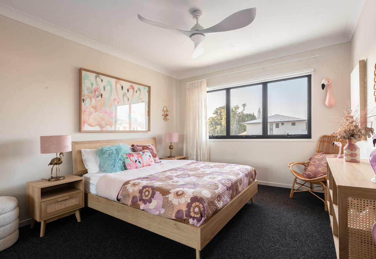 Bedroom with a Queen bed, dark carpet and a white ceiling fan.