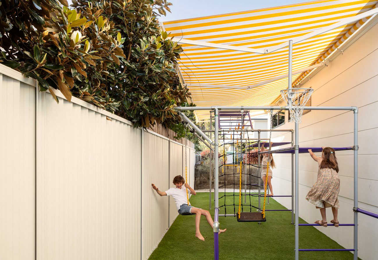 Children playing on backyard play equipment. 