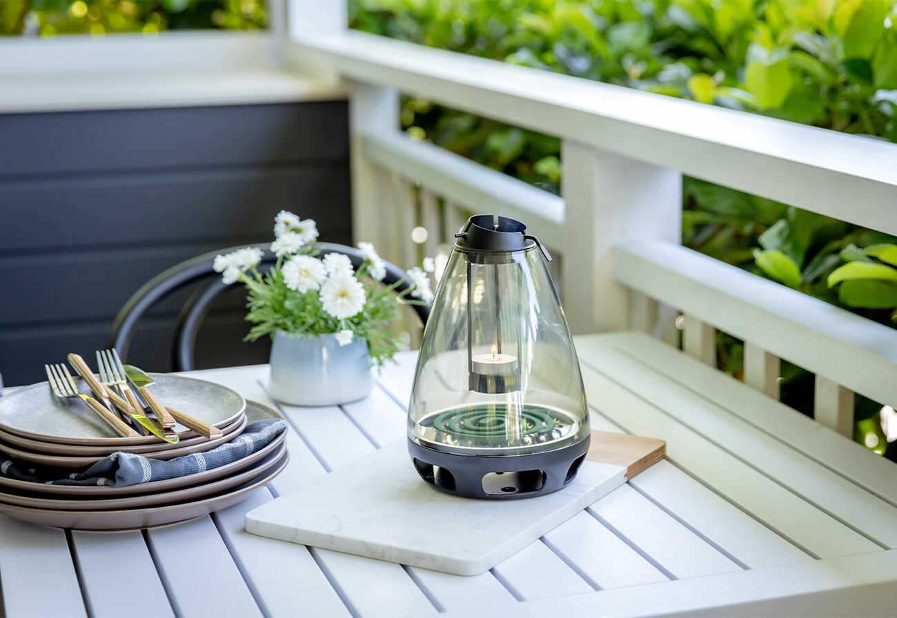 Mosquito coil burner device on an outdoor coffee table. 