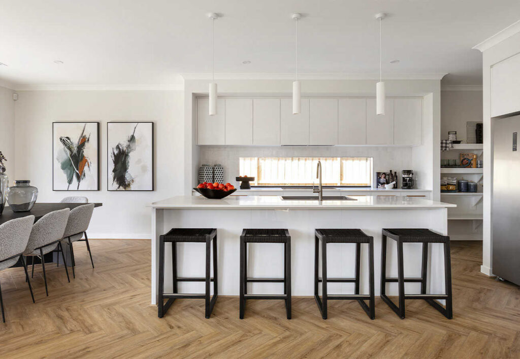 A white kitchen with window splashback and island bench.