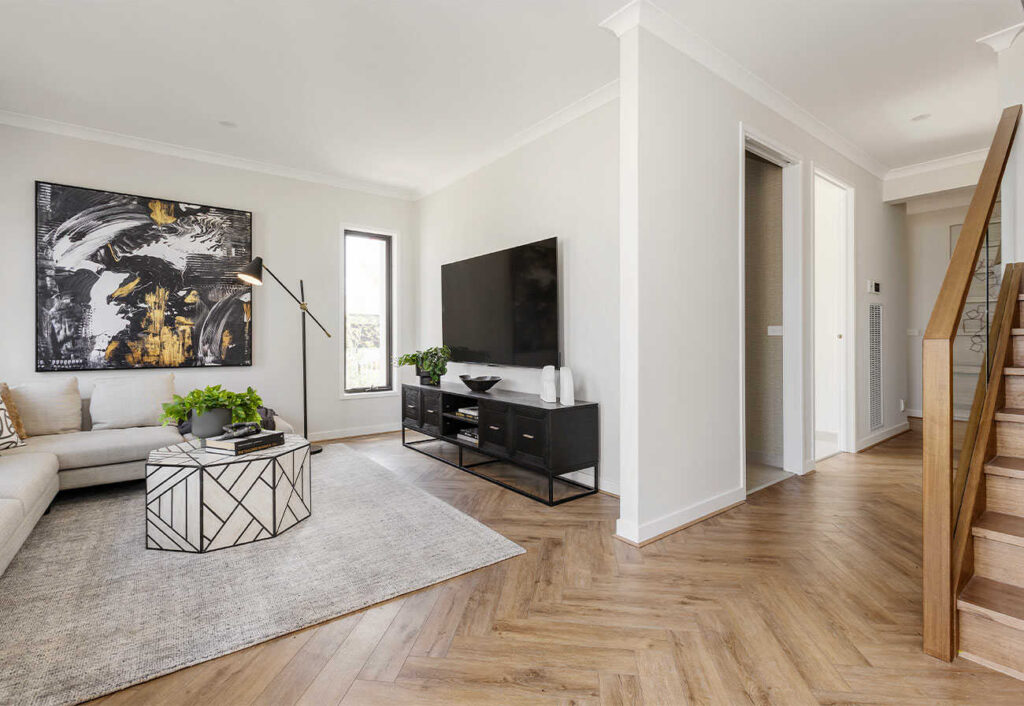 Downstairs rumpus room with a neutral rug, tv and corner couch.