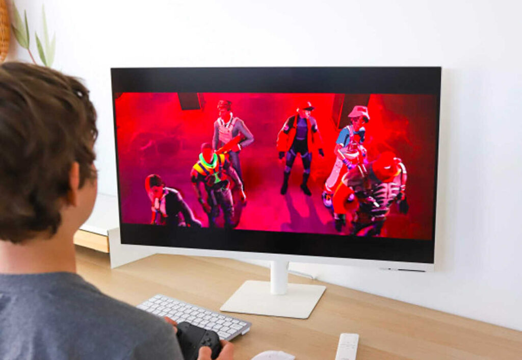 Boy playing a video game on a large monitor.