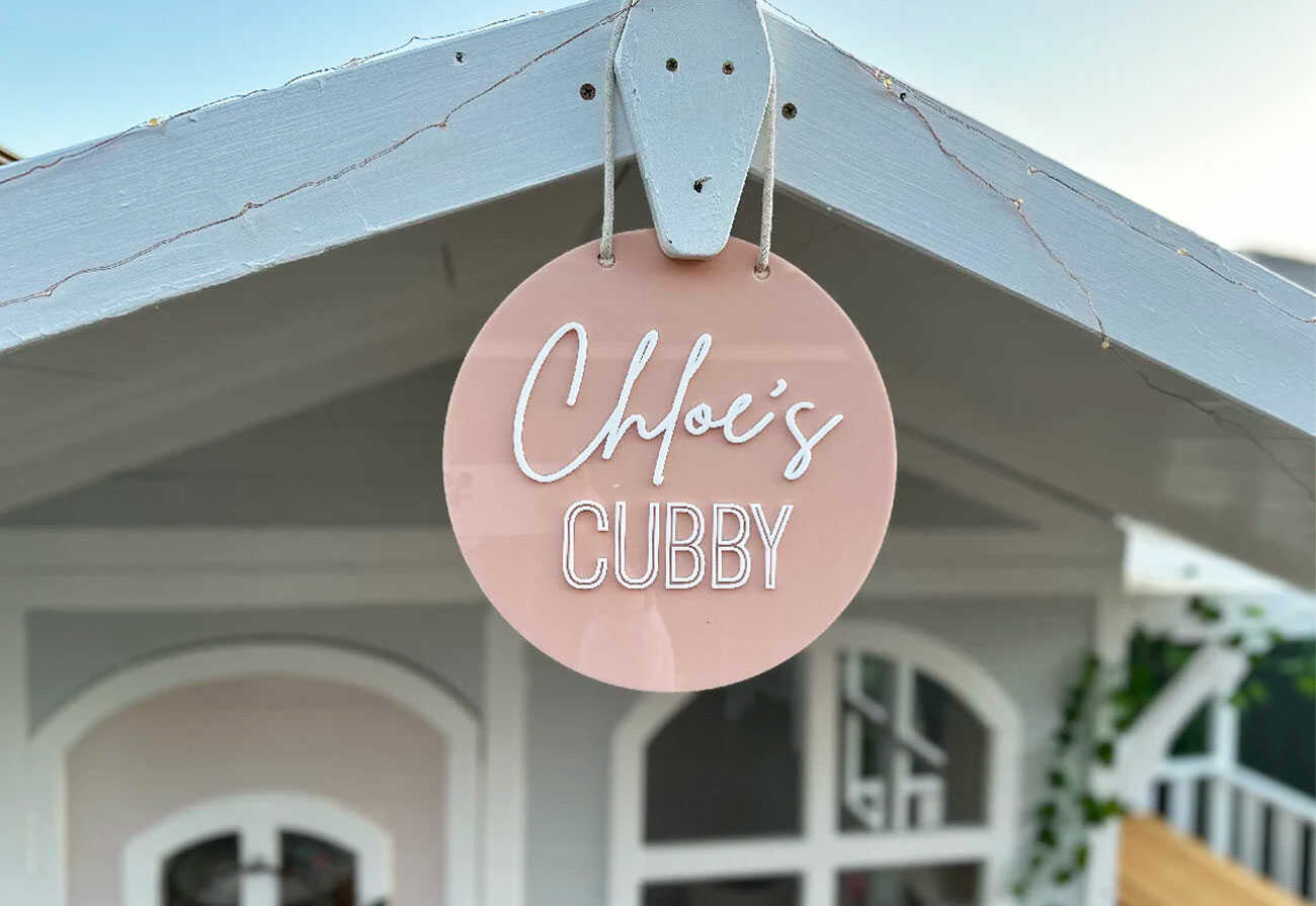 Personalised sign hangs from a child's cubby house.