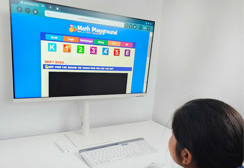 Girl doing maths work on a large monitor.