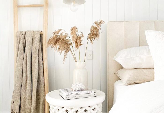 Bamboo ladder next to a bed and table.