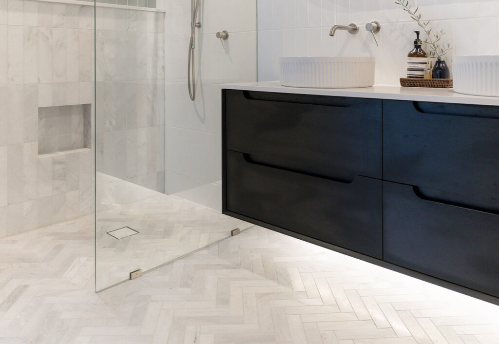 Making HOME ensuite with herringbone floor tiles and black vanity.