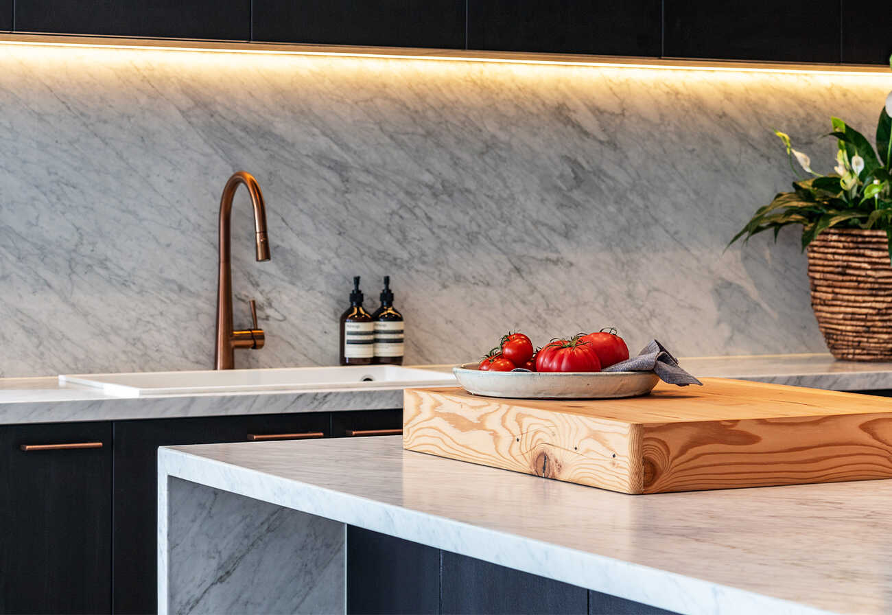 Marble benchtops and splashbacks in a modern farmhouse kitchen.