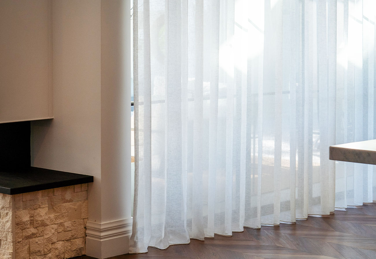 Sheer curtains leading out to an alfresco area.